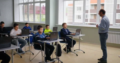 Young School Students Sitting At Tables With Laptops In Computer-Based Classroom Stock Footage 280181190