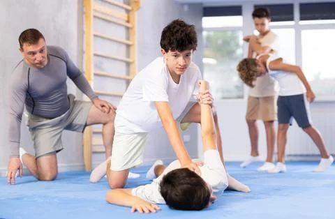 Young schoolboy practicing basic self-defense moves during training, practicing Stock-Fotos