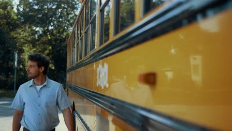 Young schoolbus driver walking along yel... | Stock Video | Pond5