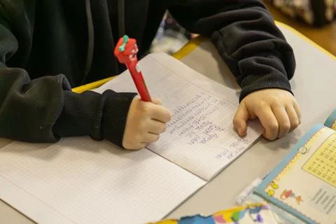 A young schoolchild writes complex math equations in a notebook at an eleme.. Stock Photos