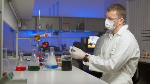 Young scientist blending colored liquid Stock Footage 127562753