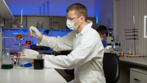 Young scientist blending colored liquid Stock Footage 127565327