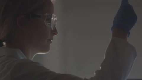 Young Scientist Closely Examines the Blue Liquid in a Test Tube Stock Footage 208708306