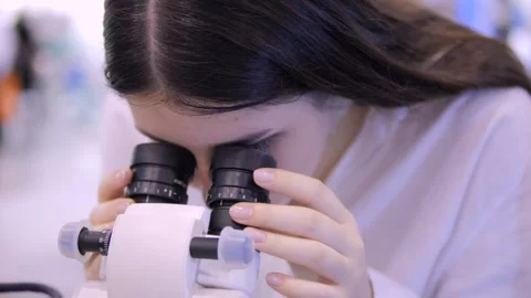 A Young Scientist Engaging in the Use of a Microscope in a Laboratory Setting Stock Footage 296732380