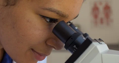 Young scientist examines a sample through a microscope. 스톡 동영상 88371844