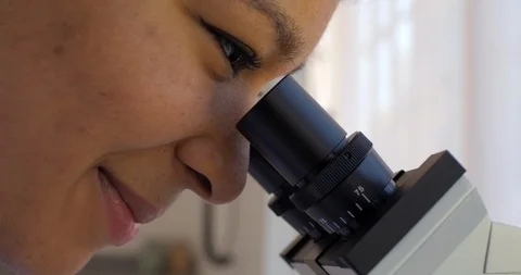 Young scientist examines a sample through a microscope. Stock-Footage 88371957