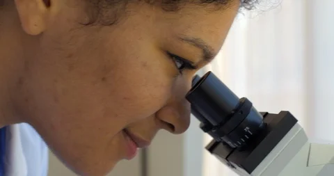 Young scientist examines a sample through a microscope. 스톡 동영상 88371974