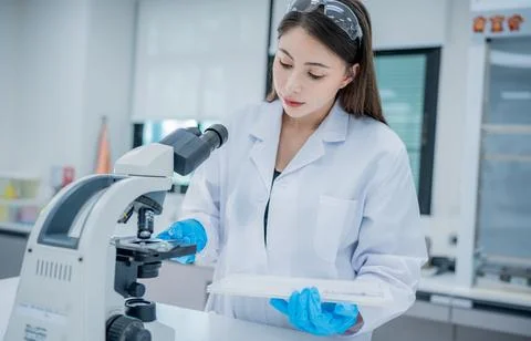 Young scientist examining samples with a microscope in a modern laboratory .. Foto stock