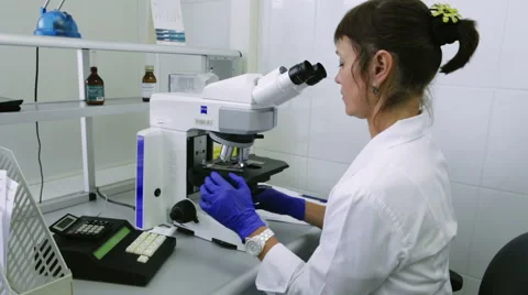 Young Scientist Female Looking Into a Microscope and Writing Data For Research Stock-Footage 60994043