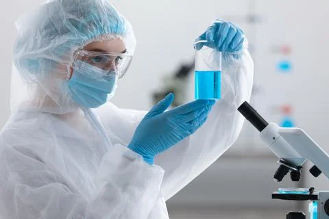 Young scientist holding beaker with sample in laboratory Foto stock