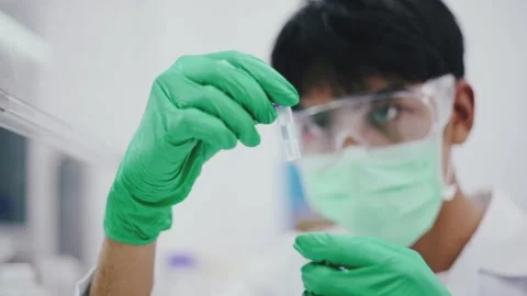 Young scientist looking at RNA Extract in Micro Centrifuge Tube for PCR test.	 Stock Footage 131551004