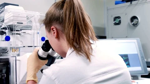 Young scientist looking through an electronic microscope 動画素材 71682878