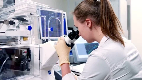 Young scientist looking through an electronic microscope Vidéo 71722502