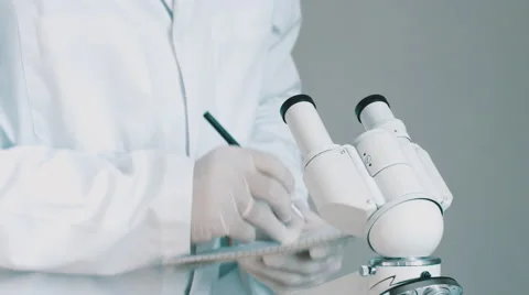 Young scientist looking through the microscope Stock Footage 67952943