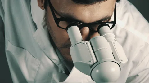 Young scientist looking through the microscope 스톡 동영상 68009443
