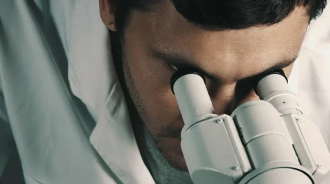 Young scientist looking through the microscope Stock Footage 68010058