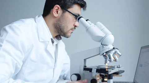 Young scientist looking through microscope Stock Footage 85141018