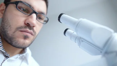 Young scientist looking through microscope 動画素材 85141253