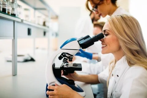 Young scientist looking through microscope in laboratory 스톡 사진