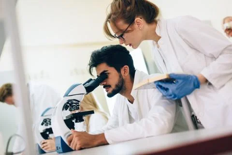 Young scientist looking through microscope in laboratory Stock Photos