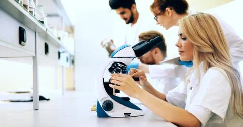 Young scientist looking through microscope in laboratory Stock Photos