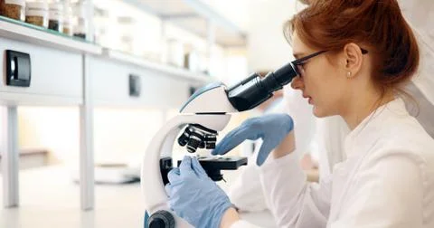 Young scientist looking through microscope in laboratory Stock Photos