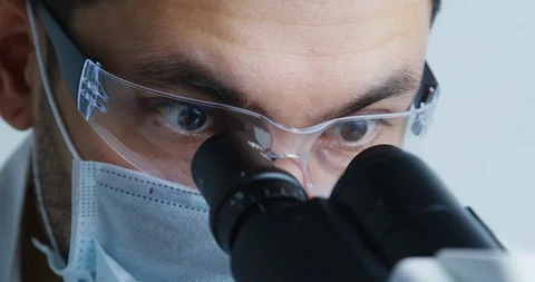 Young scientist looks under microscope. Stock Footage 120838002