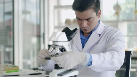 Young scientist man looking through microscope in laboratory Stock Footage 201362198