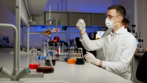 Young scientist mixing colored liquids Stock Footage 127560656