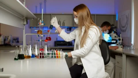 Young scientist mixing colored liquids Stock Footage 127561059