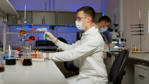 Young scientist mixing colored liquids Stock Footage 127561565