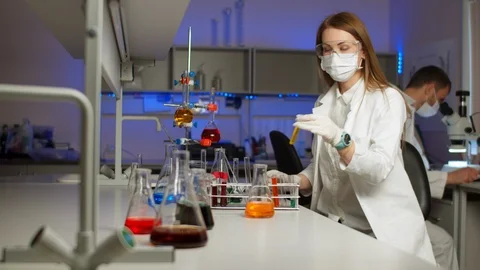 Young scientist mixing colored liquids Stock Footage 127561994