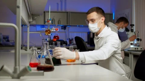 Young scientist mixing colored liquids Stock Footage 127562579