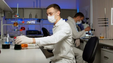 Young scientist mixing colored liquids Stock Footage 127563371