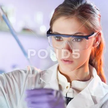 Young scientist pipetting in life science laboratory. Stock Photos