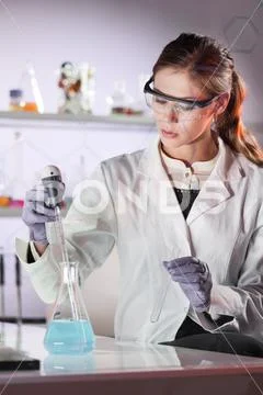 Young scientist pipetting in life science laboratory. Stock Photos