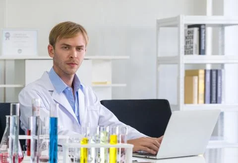 Young scientist use computers to research chemical compounds on the internet. Stock Photos