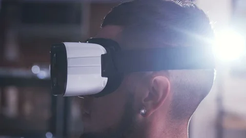 Young scientist in virtual reality goggles looking straight and testing new Stock Footage 98189843