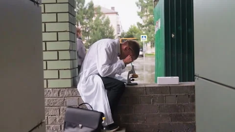 Young Scientist in White Coat Examining Pastry Through Microscope Stock Footage 321115140