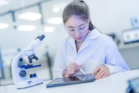 Young scientist works on tablet while analyzing samples in laboratory durin.. Fotos de archivo