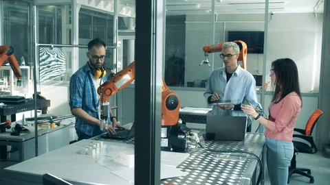 Young scientists are testing a robotic device. Young engineers working in Stock-Footage 127020232