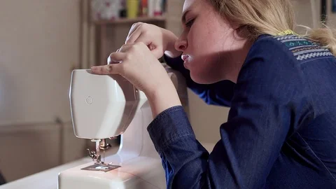 Young seamstress mending a sewing machine. The threads are tangled and stuck Видео 101870144