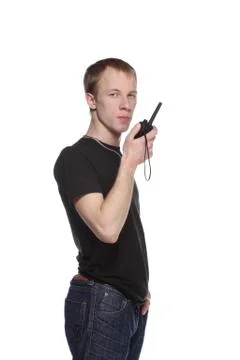 Young security officer talking through his walkie talkie. Stock Photos