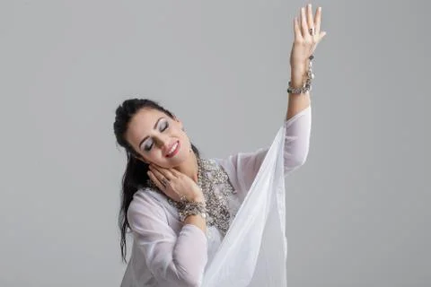 Young sensual belly dancer dancing on grey background Stock Photos