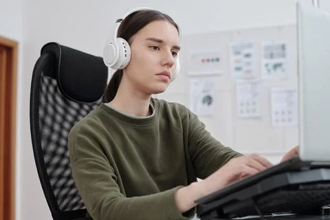 Young serious female programmer decoding data in front of computer monitor Stock Photos