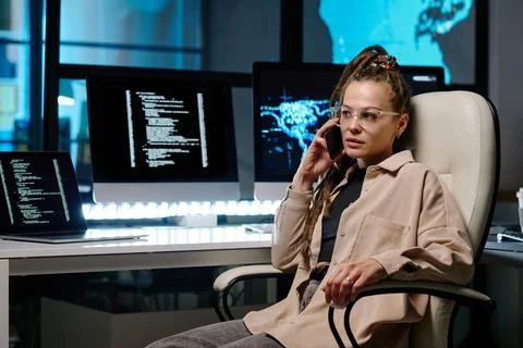 Young serious female programmer or IT support manager with smartphone Stock Photos