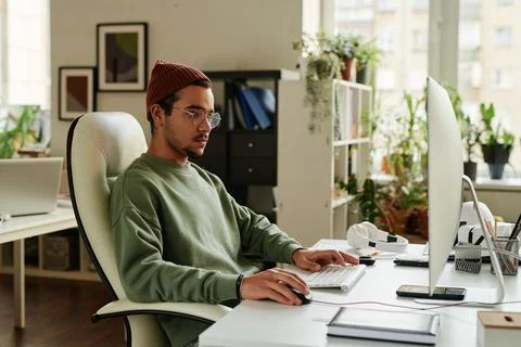 Young serious IT support engineer looking at computer screen 스톡 사진