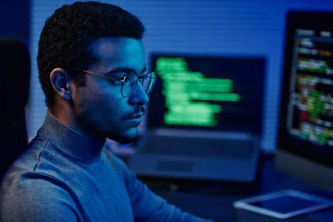 Young serious IT support engineer in eyeglasses looking at computer screen Stock Photos