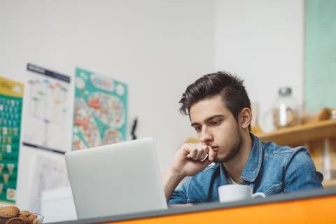 Young serious man with beard working on laptop Stock Photos