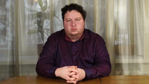 Young serious man sitting at table Stock Footage 125781643